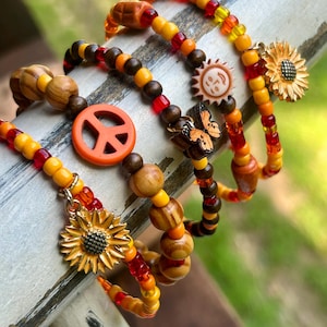 Conjunto de 5 pulseras estilo boho: girasol, símbolo de la paz, mariposa y cuentas de madera.