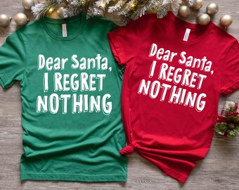 Può includere: Due magliette a tema natalizio con il testo "Caro Babbo Natale, non mi pento di nulla" in bianco su una maglietta verde e rossa.