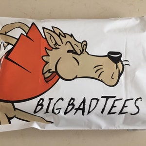 May include: White mailing envelope with a cartoon wolf wearing a red cape and the text "BIG BAD TEES".