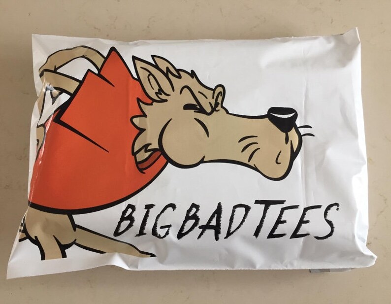 May include: White mailing envelope with a cartoon wolf wearing a red cape and the text "BIG BAD TEES".