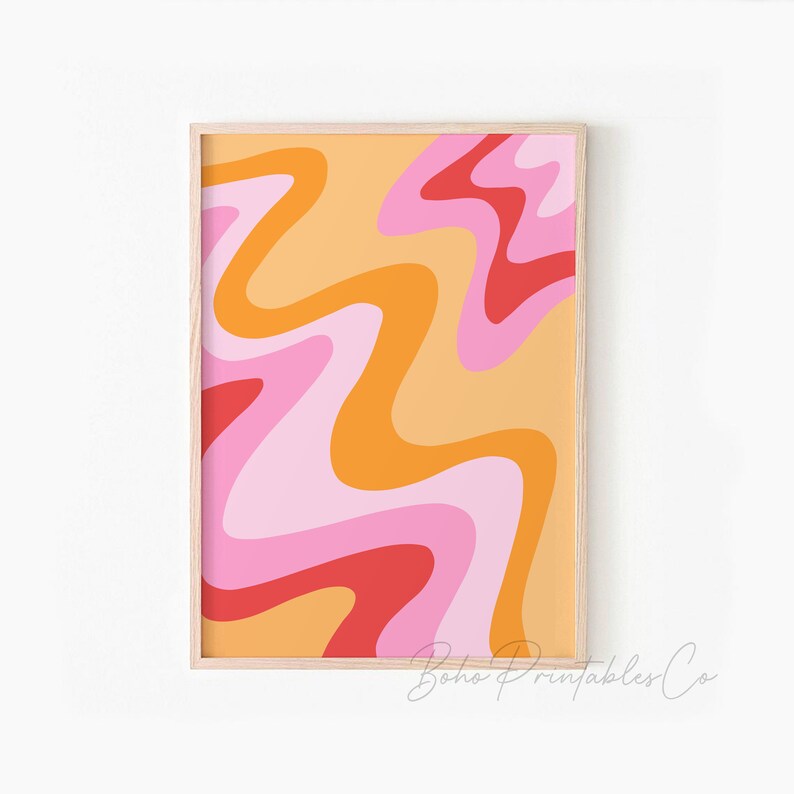 May include: Abstract wall art print with a wavy pattern in shades of pink, orange, and red. The print is framed in a light wood frame.