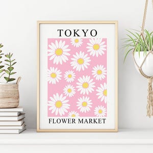 May include: A framed print with a pink background and white daisies. The print says "TOKYO FLOWER MARKET" at the bottom.