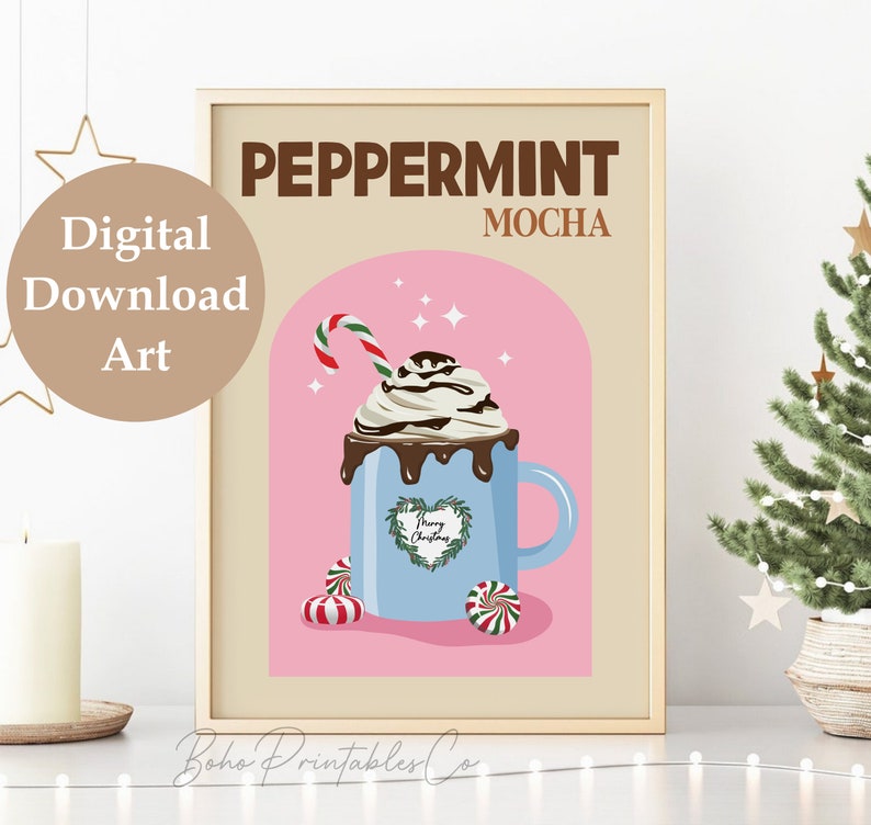 May include: A digital printable art print with a pink background and a blue mug with a peppermint mocha drink. The mug has a green wreath with the text "Merry Christmas" inside. The text "Peppermint Mocha" is at the top of the print.
