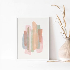 May include: Abstract art print with a white frame. The print features a design of overlapping shapes in shades of pink, peach, green, and brown.