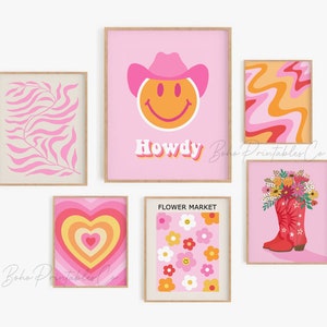 May include: A set of six pink and orange printable wall art prints featuring a smiley face wearing a cowboy hat, a heart with concentric circles, a floral bouquet in a red cowboy boot, a flower market design, a pink and orange swirl pattern, and a pink and white leaf pattern. The prints have the text "Howdy" and "Flower Market" on them.