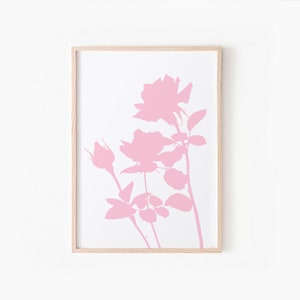 May include: A framed print of a pink silhouette of a rose bush with three roses and buds. The background is white.