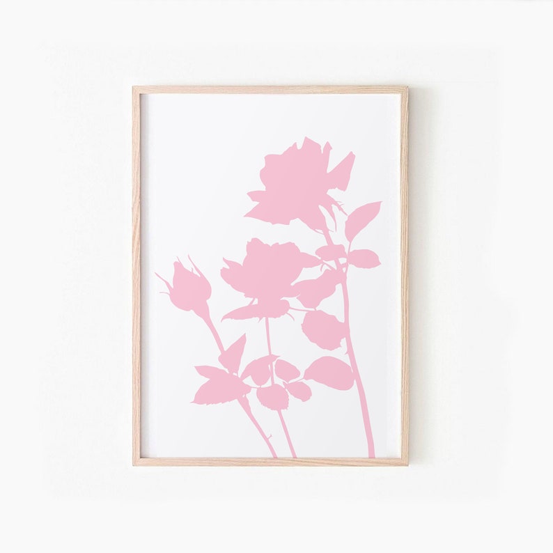 May include: A framed print of a pink silhouette of a rose bush with three roses and buds. The background is white.