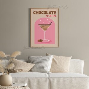 May include: A printable poster with a pink background and a brown martini glass filled with a chocolate drink. The text "CHOCOLATE MARTINI" is in brown and red letters.