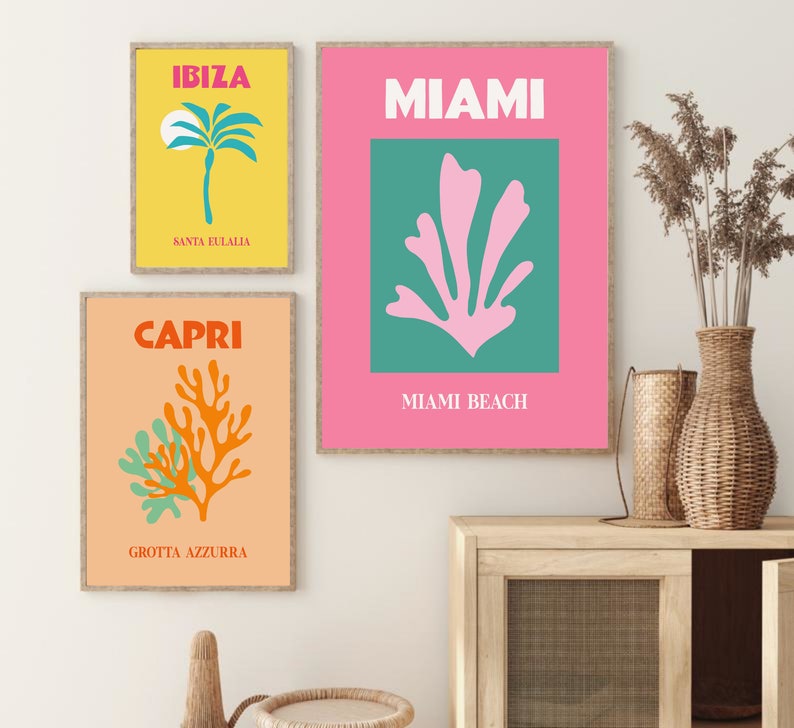 May include: Three colorful travel posters with illustrations of a palm tree, a coral reef, and a sea plant. The posters are framed in wood and have the text "IBIZA SANTA EULALIA", "MIAMI MIAMI BEACH", and "CAPRI GROTTA AZZURRA".