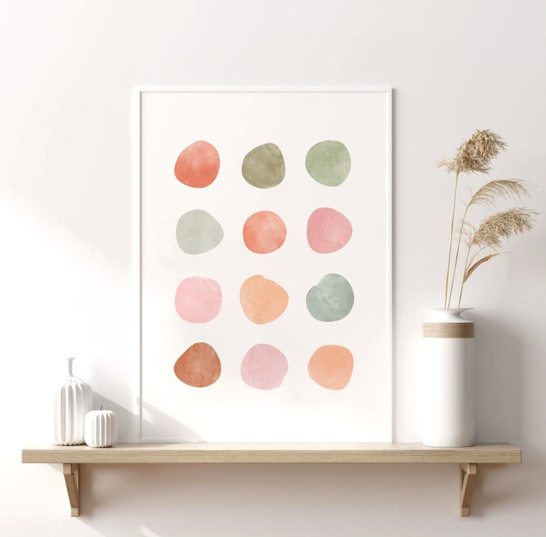 May include: A framed print with a white background and 15 abstract watercolor circles in shades of pink, orange, green, and brown.