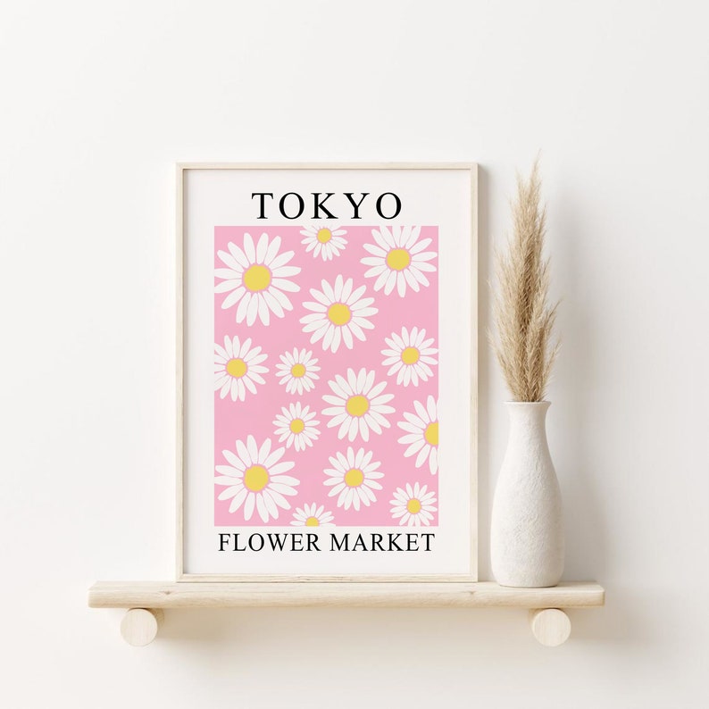 May include: A framed print with a pink background and white daisies. The print says "TOKYO FLOWER MARKET" in black text.
