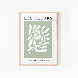 May include: A framed print with a green background and a white abstract floral design. The text "LES FLEURS" is at the top and "LA MAISON BOHEME" is at the bottom.
