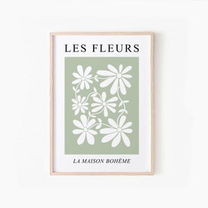 May include: A framed print with a green background and white stylized flowers. The text "LES FLEURS" is at the top and "LA MAISON BOHEME" is at the bottom.