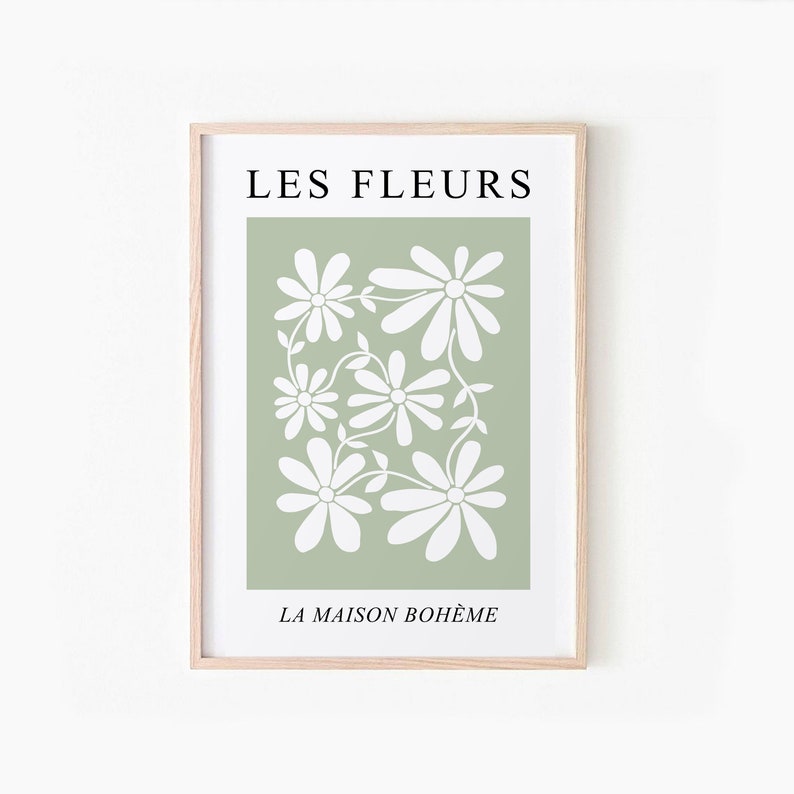 May include: A framed print with a green background and white stylized flowers. The text "LES FLEURS" is at the top and "LA MAISON BOHEME" is at the bottom.