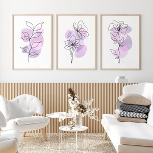 May include: Three minimalist line art prints with purple watercolour accents. The prints feature a butterfly, a flower, and a leafy branch.