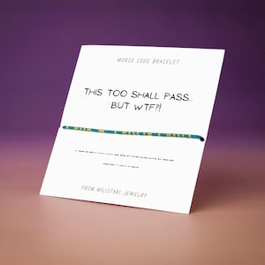 May include: A teal and gold beaded Morse code bracelet displayed on a white card. The card features the text "MORSE CODE BRACELET", "THIS TOO SHALL PASS... BUT WTF?!", and "FROM MILISTARI JEWELRY" along with a printed Morse code sequence.