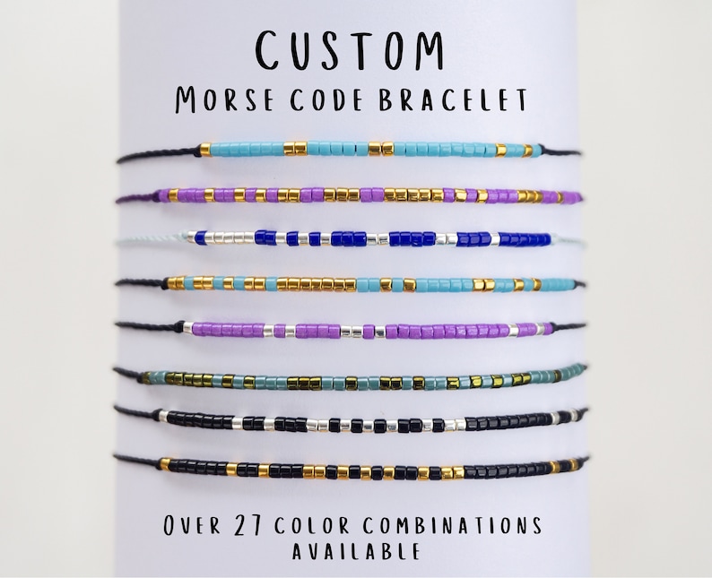 May include: A set of custom Morse code bracelets with different color combinations. The bracelets are made with small beads in various colors, including blue, purple, green, black, and gold. The text "CUSTOM MORSE CODE BRACELET" is at the top of the image, and the text "OVER 27 COLOR COMBINATIONS AVAILABLE" is at the bottom.