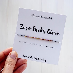 May include: A white card with the text "Morse code bracelet Zero Fucks Given" and the morse code for the phrase below. The card also includes the text "from Milistariejewelry".