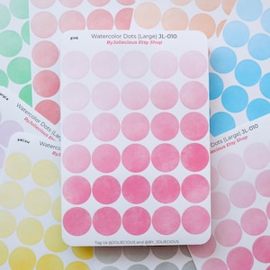 May include: A sheet of 49 large watercolor dot stickers in shades of pink. The stickers are arranged in a grid pattern. The sheet is labeled "Watercolor Dots (Large) JL-010 ByJoliecious Etsy Shop".