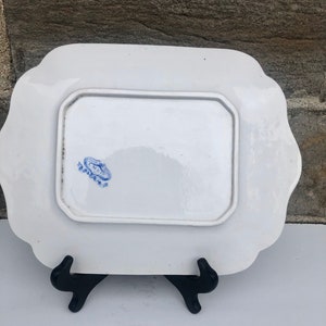 May include: White porcelain serving platter with a blue and white floral design. The back of the platter has a blue stamp that reads "Royal Doulton".
