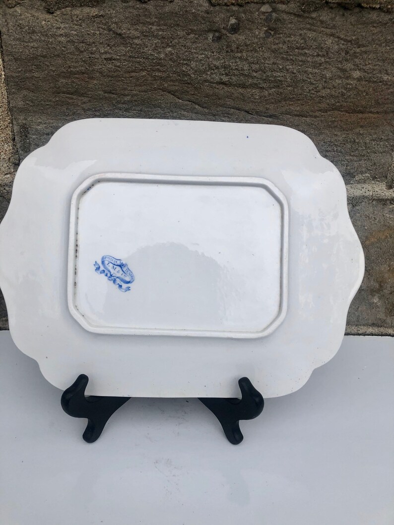 May include: White porcelain serving platter with a blue and white floral design. The back of the platter has a blue stamp that reads "Royal Doulton".