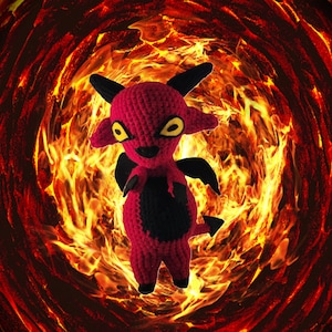 May include: A crocheted red devil with black horns and a black tail, against a background of swirling flames.