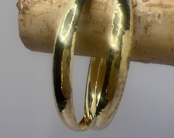 May include: Two gold-toned metal bangles with a hammered texture.
