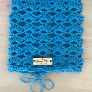 May include: A bright blue crocheted cowl with a wooden tag that reads "Gracy Mac Crochet". The cowl has a tie closure.