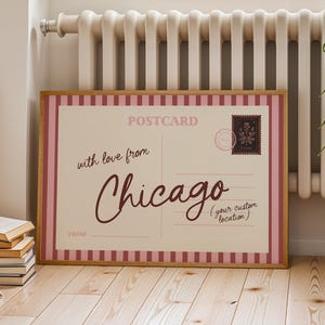 Könnte beinhalten: Ein rechteckiger gerahmter Druck im Design einer Vintage-Postkarte mit einem rosa-weiß gestreiften Rand. Die cremefarbene Mitte zeigt den Text POSTCARD, with love from Chicago und (your custom location) in dunkelbrauner Schreibschrift.
