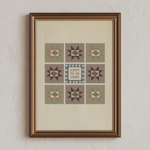 May include: A framed wall art print featuring a grid of nine squares, each containing a geometric star pattern in muted shades of green, brown, and pink. The centre square displays the text HAPPY TO BE HOME surrounded by a blue and white dotted border.