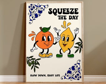 May include: A framed print with a white background featuring a cartoon orange and lemon with the text "Squeeze the Day" and "Slow Down, Enjoy Life". The print has a blue and white floral border.