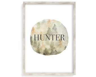 May include: A framed print with a watercolor illustration of a forest scene in shades of green, brown, and orange. The word "HUNTER" is written in black text over the forest scene.
