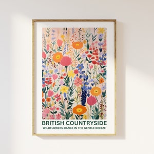 K&ouml;nnte beinhalten: Ein gerahmter Kunstdruck mit einer farbenfrohen Illustration von Wildblumen auf einem Feld. Das Kunstwerk zeigt eine Vielzahl von Blumen in Rosa-, Orange-, Gelb- und Blaut&ouml;nen. Der Text "BRITISH COUNTRYSIDE" und "WILDFLOWERS DANCE IN THE GENTLE BREEZE" ist unten abgebildet.