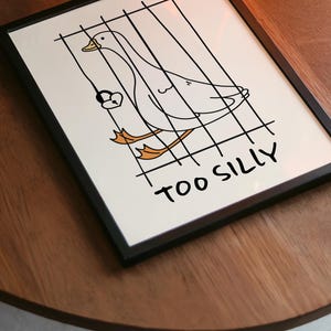 Bring a smile to your space with this Too Silly goose art print! A funny, minimalist illustration featuring a cheeky goose behind bars for being “too silly.” Perfect for adding personality to your home, office, or gallery wall.
This quirky silly goose animal print makes a wonderful gift for friends who love humor, cottagecore whimsy, or modern minimalist art. Designed to brighten up any corner and spark joy daily.