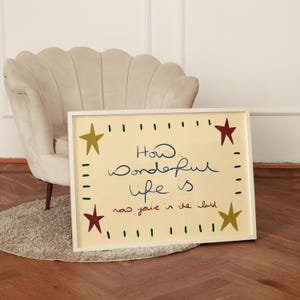 “Retro mid-century quote art print with stars and handwritten text reading ‘How wonderful life is now you’re in the world’ in warm vintage colours.”