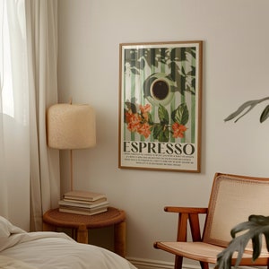 May include: A framed art print featuring an espresso design. The artwork showcases a coffee cup, floral elements, and the word "ESPRESSO" in a vintage style. The print is displayed on a wall in a room with a lamp and a chair.