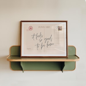 a vintage postcard style print, with the phrase it feels so good to be home