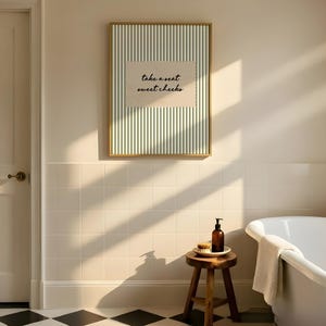 Funny bathroom wall art featuring olive green vertical pinstripes with a distressed cream scalloped label reading “take a seat sweet cheeks” in black handwritten script. Minimal vintage heritage inspired bathroom print with playful typography and a cosy boutique hotel aesthetic for guest bathrooms or powder rooms.