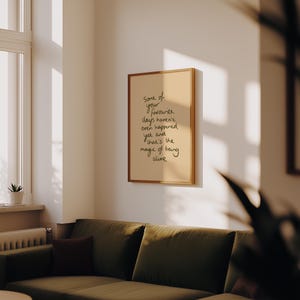 Minimalist typography print featuring the quote "Some of your favourite days haven't even happened yet and that's the magic of being alive" in an organic handwritten script. Warm beige background with olive green lettering creates a calming, hopeful and uplifting piece of inspirational wall art with a simple modern aesthetic.