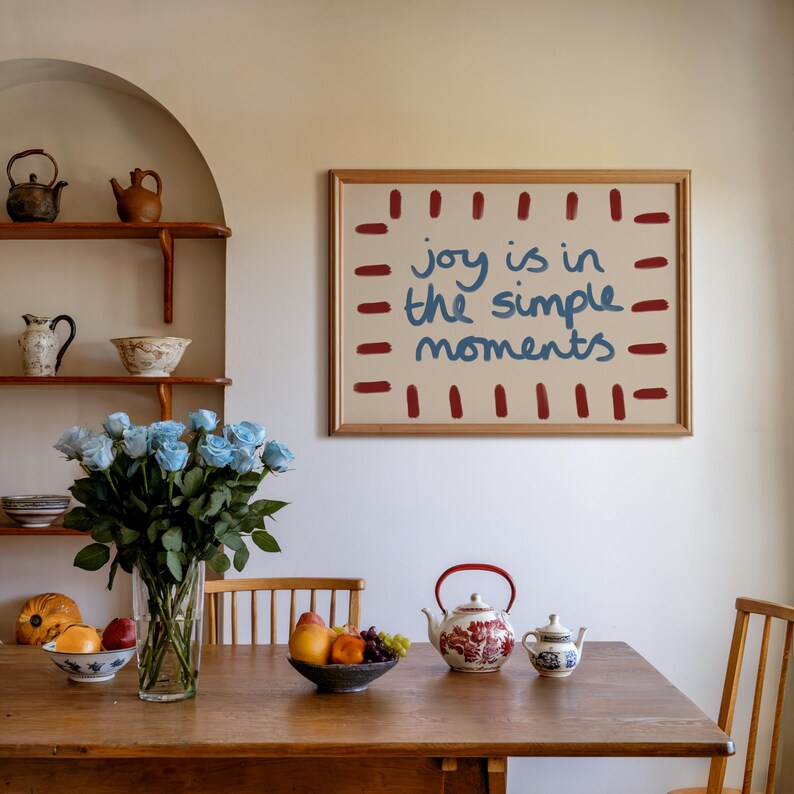 Celebrate the beauty of life’s simple pleasures with this "Joy Is in the Simple Moments" Hand-Drawn Typography Print. Featuring a retro mid-century design with red, blue and beige tones, this artwork embodies a laid-back, playful vibe perfect for a dopamine driven space.