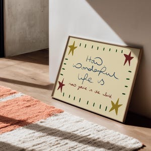 “Retro mid-century quote art print with stars and handwritten text reading ‘How wonderful life is now you’re in the world’ in warm vintage colours.”