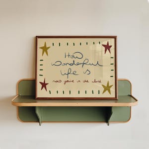 “Retro mid-century quote art print with stars and handwritten text reading ‘How wonderful life is now you’re in the world’ in warm vintage colours.”
