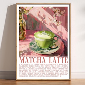 Può includere: Una stampa incorniciata con un matcha latte. La bevanda verde è in una tazza e un piattino verdi, con un cucchiaio. Il latte ha un disegno a forma di cuore sulla parte superiore. La stampa ha le parole "MATCHA LATTE".