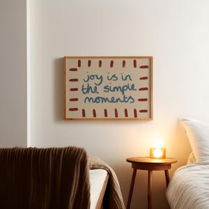 Celebrate the beauty of life’s simple pleasures with this "Joy Is in the Simple Moments" Hand-Drawn Typography Print. Featuring a retro mid-century design with red, blue and beige tones, this artwork embodies a laid-back, playful vibe perfect for a dopamine driven space.