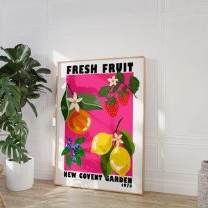 May include: A pink poster with the text "FRESH FRUIT NEW COVENT GARDEN 1974" and illustrations of a lemon, orange, strawberries, and blueberries.