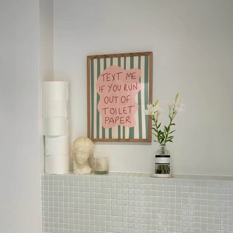 Funny bathroom wall art print with pink blob and wavy green stripes that reads “Text Me If You Run Out Of Toilet Paper”.