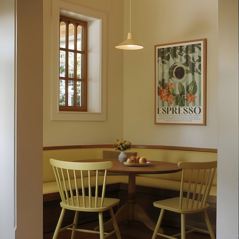 May include: A dining area with a round wooden table, two chairs, and a built-in bench. A framed poster with the word "ESPRESSO" hangs on the wall. A window with a wooden frame is visible. A light fixture hangs above the table.