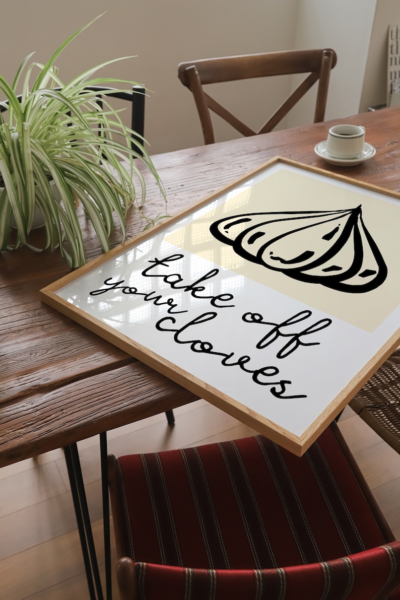 Op de afbeelding: Een ingelijst print met een witte achtergrond en zwarte tekst die "take off your clothes" luidt. De print bevat een zwart-witte illustratie van een schelp.