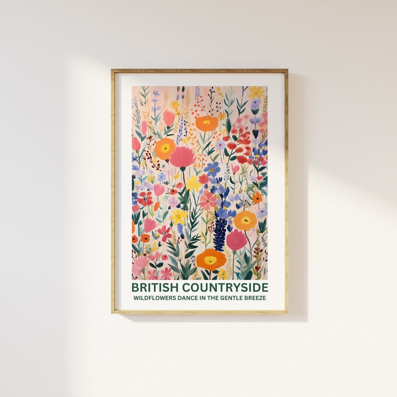 K&ouml;nnte beinhalten: Ein gerahmter Kunstdruck mit einer farbenfrohen Illustration von Wildblumen auf einem Feld. Das Kunstwerk zeigt eine Vielzahl von Blumen in Rosa-, Orange-, Gelb- und Blaut&ouml;nen. Der Text "BRITISH COUNTRYSIDE" und "WILDFLOWERS DANCE IN THE GENTLE BREEZE" ist unten abgebildet.