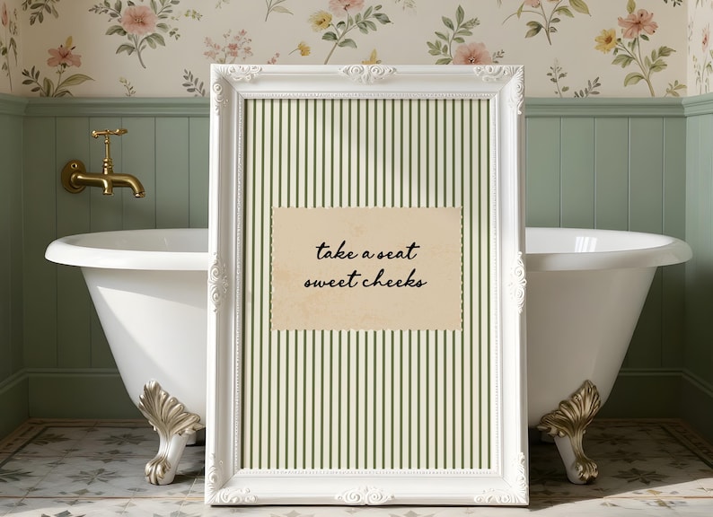 Funny bathroom wall art featuring olive green vertical pinstripes with a distressed cream scalloped label reading “take a seat sweet cheeks” in black handwritten script. Minimal vintage heritage inspired bathroom print with playful typography and a cosy boutique hotel aesthetic for guest bathrooms or powder rooms.